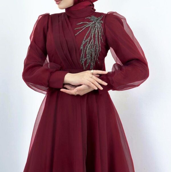 Close up photo of Burgundy Princess Hijab Dress worn by a model, showcasing a sophisticated and modest design, available at Noor Boutique in the GTA.