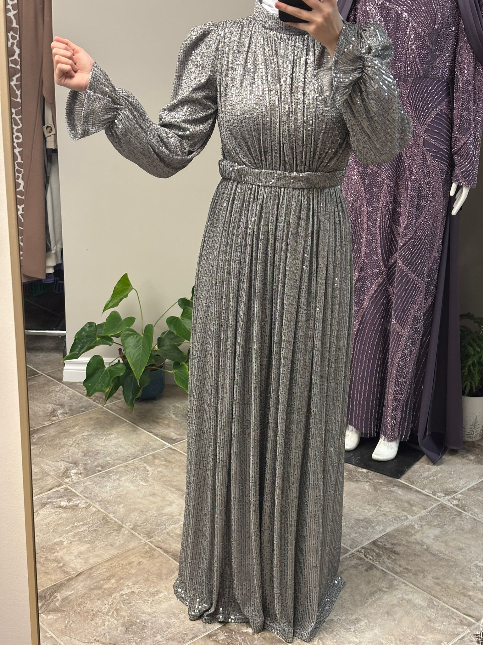 Silver Evening Hijab Dress worn by a model, featuring a shimmering fabric and a graceful modest design, available at Noor Boutique in the GTA.