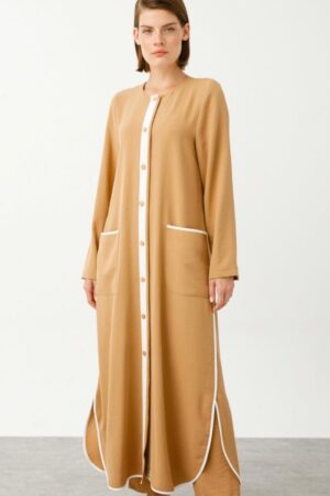 Camel Abaya with Delicate White Detailing worn by a model, showcasing intricate white accents and a modest silhouette, available at Noor Boutique in the GTA.