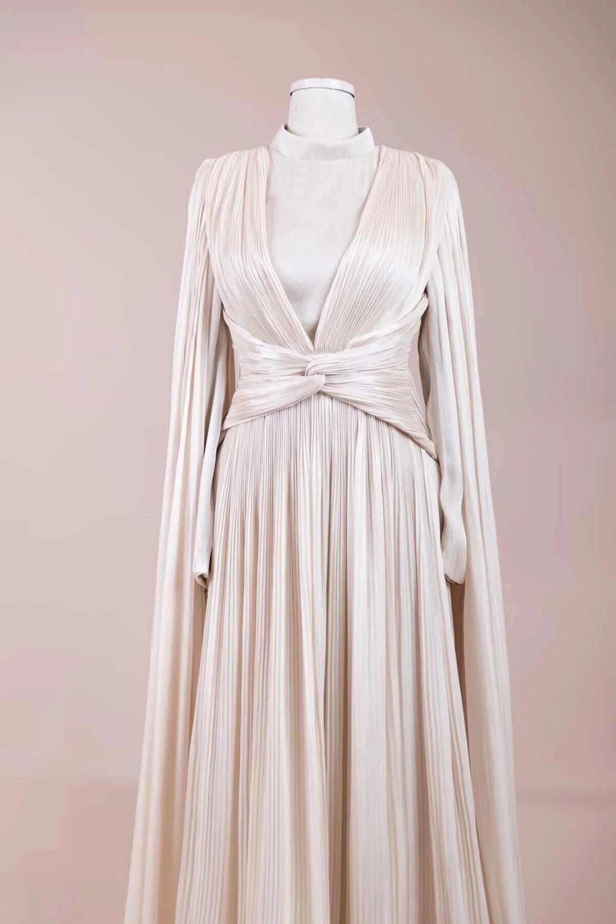 Cream pleated evening gown back view with cape sleeves
